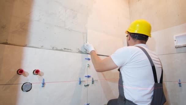 タイルメーカーは バスルームの壁にタイルを敷設の仕事を実行します タイルの作品 — ストック動画