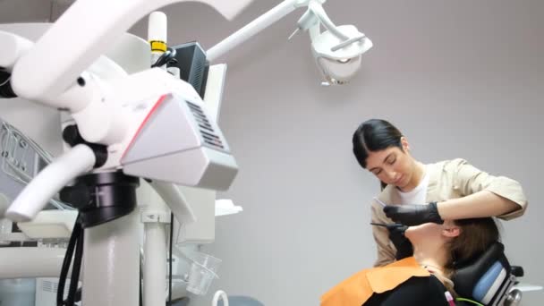 一位漂亮的年轻女牙医正在治疗一位坐在现代牙科诊所的年轻病人的牙齿 及时治疗牙齿 现代牙科技术 — 图库视频影像