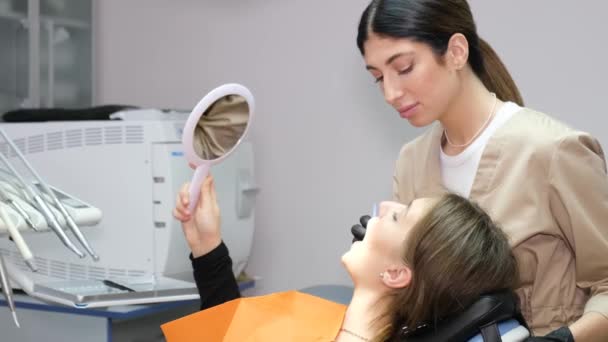 牙科医生和牙科治疗期间的病人 病人坐在舒适的牙椅上 看着牙镜 现代牙科无痛牙科治疗 — 图库视频影像