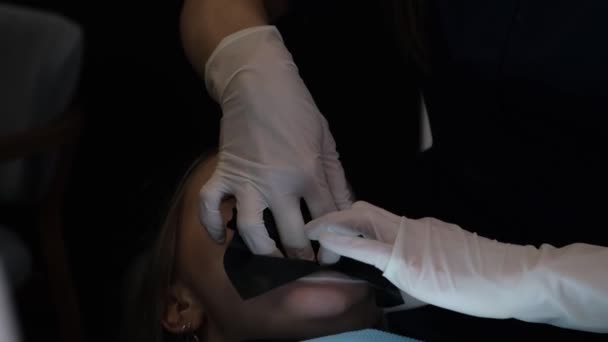 歯科事務所での歯科治療のプロセス 歯医者と彼の助手は口腔の患者を処理する — ストック動画