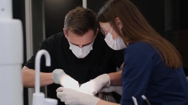 牙医和他的助手在牙科治疗过程中使用现代治疗方法 及时治疗口腔疾病 — 图库视频影像