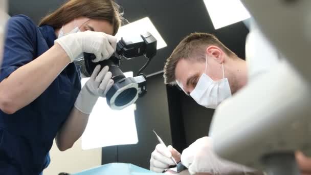 現代の技術やツールを使用して女性の歯を治療するプロセス 歯科治療プロセスの写真とビデオ記録 健康な歯の概念 — ストック動画