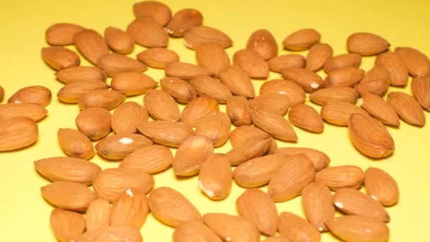 Raw Natural Organic Almonds Nuts Scattered Isolated Yellow Background View — Αρχείο Βίντεο