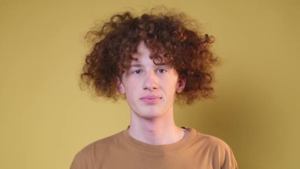 Açık Kahverengi Arka Planda Güzel Kıvırcık Saçlı Pozitif Genç Bir — Stok video