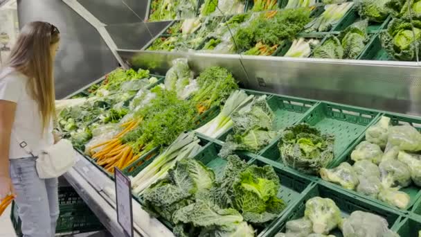 Young Woman Buys Vegetables Market She Examines Carrots Concept Vegetarianism — стокове відео