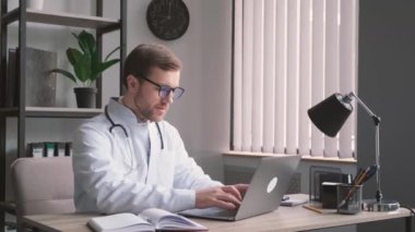 Genç çekici bir nörolog ofiste oturur ve bilgisayarın başında çalışır. Genç bir stajyer netbook 'ta çalışıyor.