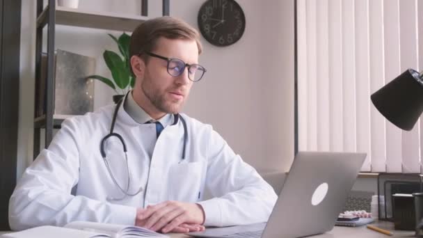 Médico Cardiologista Cansado Barbudo Atraente Sentado Escritório Trabalhando Computador Médico — Vídeo de Stock