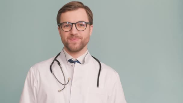 Wahnsinnig Glücklicher Lächelnder Junger Arzt Europäischen Aussehens Posiert Auf Blauem — Stockvideo