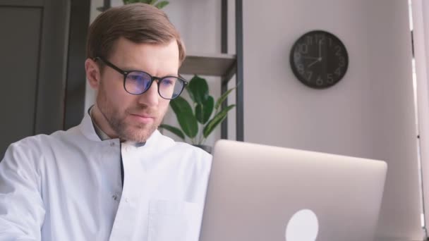 Gözlüklü Üniformalı Ciddi Bir Doktor Bilgisayardaki Ofisinde Çalışıyor Doktorun Elektronik — Stok video