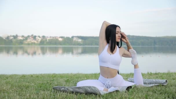 Vacker Brunett Gör Yoga Bakgrunden Sjö Morgonträning Utomhus — Stockvideo