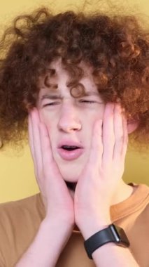 Negative emotions on the camera of a young man, a student with curly hair. The emotion of disgust, revulsion. Vertical video