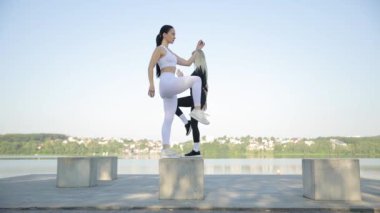Parkın dışında spor yaparken genç, pozitif bayan eğitmen. Güzel kadınlar spor yapar.