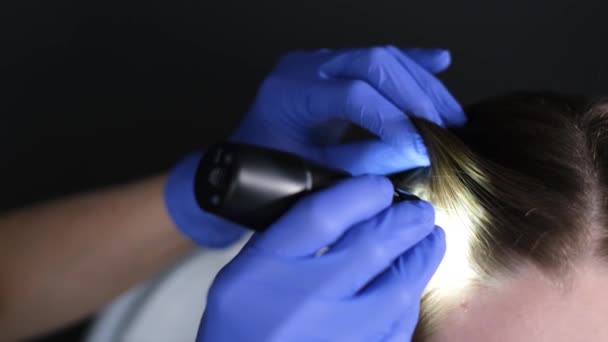 化粧品学者 豊富な専門家は トリコスコープの助けを借りて患者の髪の状態を診断する — ストック動画