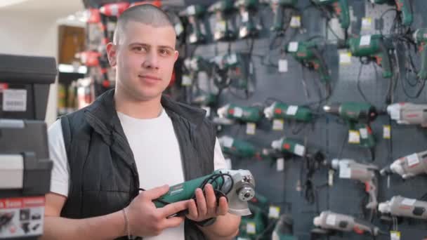Joven Vendedor Sostiene Una Lijadora Una Ferretería Departamento Reparación Electrodomésticos — Vídeos de Stock