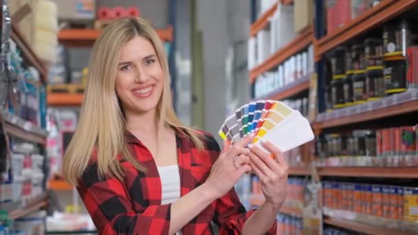 긍정적 컨설턴트는 용품의 배경에 페인트 색상의 팔레트를 보여줍니다 슈퍼마켓에서 색상을 — 비디오