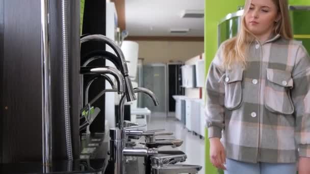 在一家大型五金店的水暖部门 一位白人妇女在挑水龙头 现代化的饮水机 — 图库视频影像
