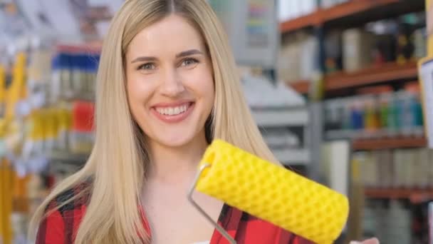 Güzel Gülümseyen Sarışın Bir Kadın Rafların Arkasında Sarı Bir Boya — Stok video