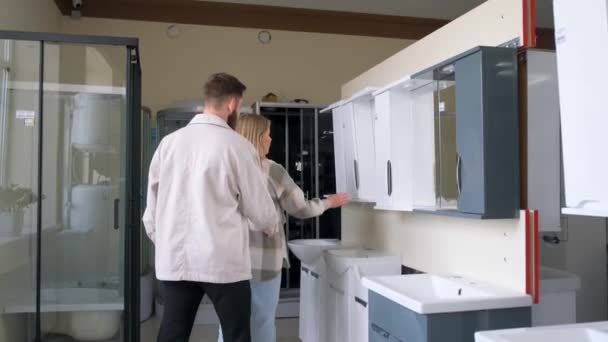 バスルームの家具部門の若いカップル 夫と妻は新しいバスルームのための家具を選択します バスルームインテリアデザイン — ストック動画