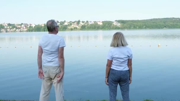 Szczęśliwa Starsza Europejska Rodzina Robi Poranne Ćwiczenia Nad Jeziorem Koncepcja — Wideo stockowe
