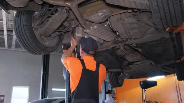 Car Mechanic Overalls Repairs Wheels Car Standing Lift Car Workshop — Stock Video