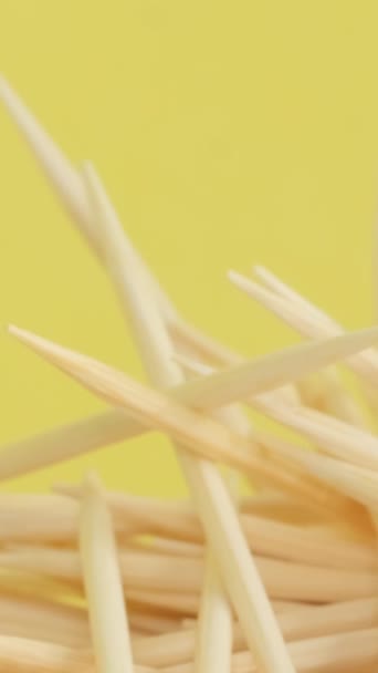 マクロビデオ 黄色の背景に歯磨き シャープな木製のスティック 口腔衛生について バーティカルビデオ — ストック動画