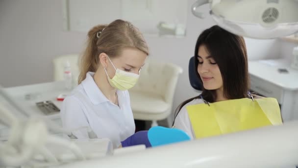 歯医者の予約でブルネットの若い女の子 白い歯科インプラントの設置 歯医者さんの仕事 — ストック動画