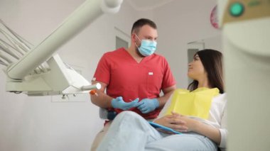 Dişçi silikon takmaktan bahsediyor. Diş hekimliği kliniğindeki bir kadın hasta. Diş tedavisi kavramı