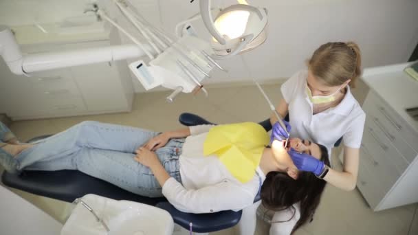 Professionell Kvinnlig Tandläkare Undersöker Patient Med Ett Speciellt Instrument Och — Stockvideo