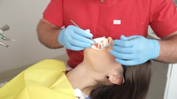 Ένας Αρσενικός Οδοντίατρος Εξετάζει Δόντια Των Ασθενών Χρησιμοποιώντας Ιατρικά Όργανα — Αρχείο Βίντεο