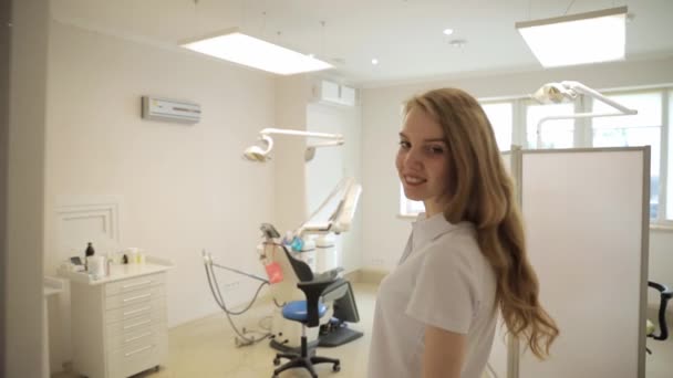 女性の歯科医がオフィスに入って笑顔になる 歯医者さん 美しい笑顔 現代歯科 — ストック動画