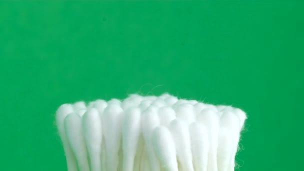 Cotton swabs on a green background. Chromakey background. Close-up. Vertical video.