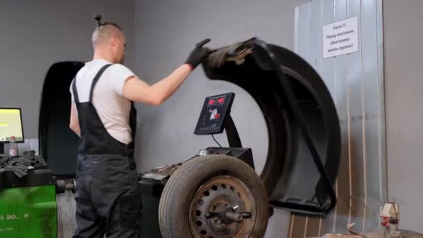 Ένας Μηχανικός Αυτοκινήτων Ισορροπεί Τροχούς Μια Ειδική Εγκατάσταση Επισκευή Ελαστικών — Αρχείο Βίντεο