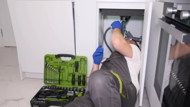 一名穿着防护工作服和手套的管道工正在做管道工程 替换一个旧的破水池过滤器 管道工程 垂直录像 — 图库视频影像