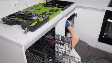 Mutfak odasına lavabo döşeyen bir tesisatçı. Yeni bir binada tamirat. Dikey video.