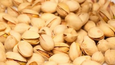 Super slow motion of pistachios falling on a brown background at 240fps.