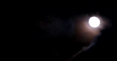 A bright yellow moon at night among the clouds. Astrology concept.