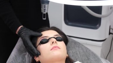 A young girl undergoes laser removal of permanent makeup in a beauty salon. Correction of eyebrows.