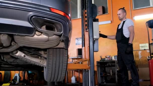 Car Mechanic Diagnoses Cars Undercarriage Raised Car Repair Station Car — Αρχείο Βίντεο