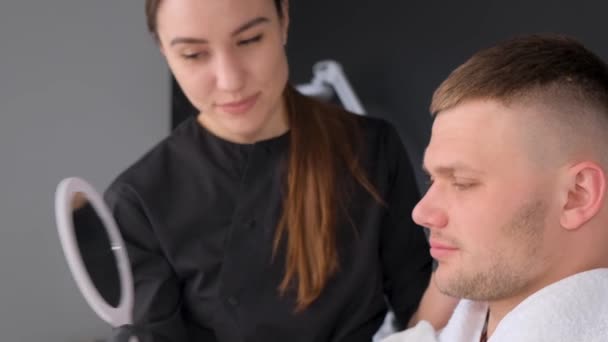 Client Satisfait Esthéticienne Regarde Dans Miroir Suite Massage Visage Cosmétologie — Video