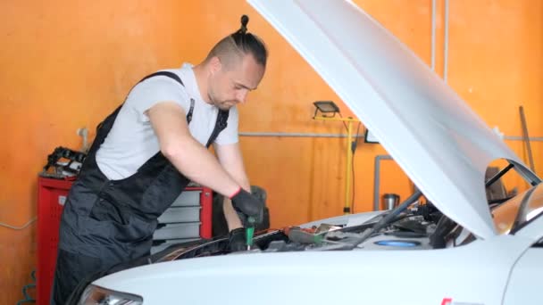 機械は白い車を修理し 車のエンジンを点検する 車の修理サービス バーティカルビデオ — ストック動画
