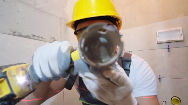 Ein Bauarbeiter Benutzt Einen Elektrobohrer Der Die Kameralinse Blickt Sanierungskonzept — Stockvideo