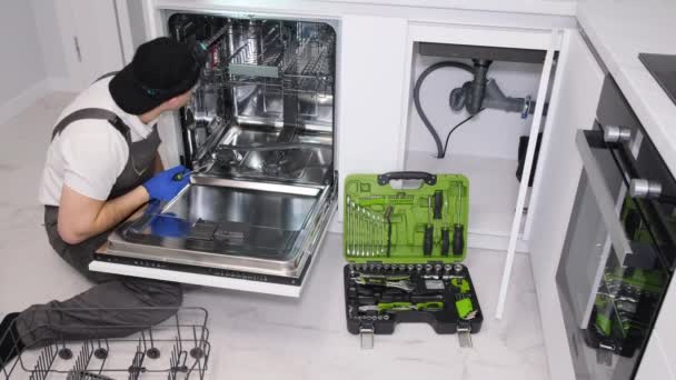 Young Repairman Repairing Broken Dishwasher Modern Kitchen — Αρχείο Βίντεο