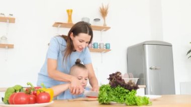 Mutlu bir anne çocuklarıyla mutfakta yemek pişiriyor. Evde yemek yeme kavramı. Dikey video