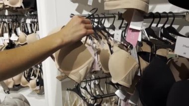A young woman buys a bra in a lingerie store. Shopping in stores.