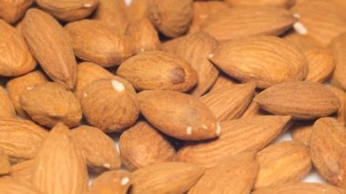 Rotating background of almonds. Tasty and useful almond as full frame. Fried almonds. Scattered almond grains. Natural almond close-up.