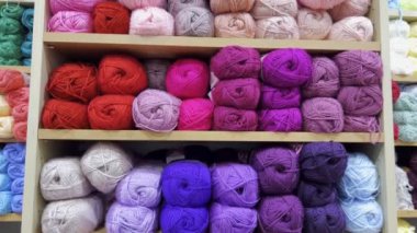 Close-up of woolen threads of different colors in a store on a shelf.