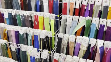 Many different zippers for clothes in different sizes and colors, Lightnings are placed on racks in the workshop of a clothing atelier.