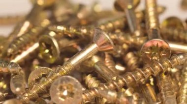 Metal screws in the furniture workshop rotate in a circle. Use of fasteners when working with wood. Macro video