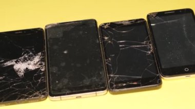 Old broken smartphone. Smartphones on a yellow background. Smart Phone with broken screen. Broken texture.