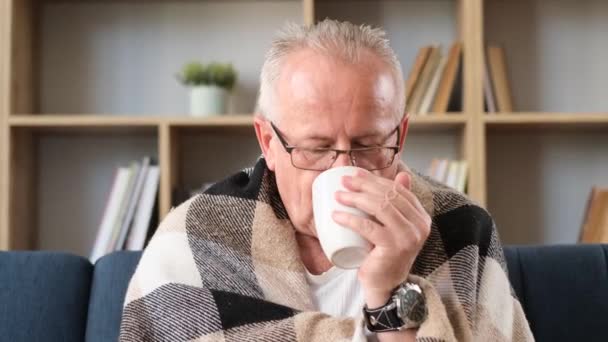 爷爷戴着眼镜喝茶 他感冒了 流鼻涕 生病的老人 垂直录像 — 图库视频影像